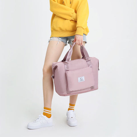 CJ pink convertible backpack handbag held by person wearing yellow sweatshirt and white sneakers