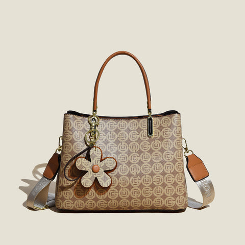 CJ floral pendant crossbody bag in beige with brown handles and logo pattern design