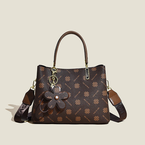 CJ floral pendant crossbody bag in brown with flower charm and adjustable strap