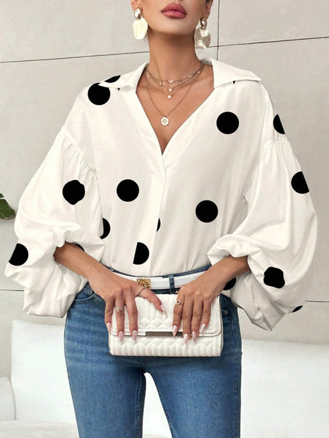 Polka dot, loose-fitting, puff-sleeved top with a semi-open collar.