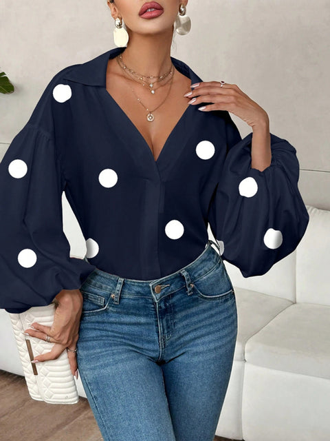 Polka dot, loose-fitting, puff-sleeved top with a semi-open collar.