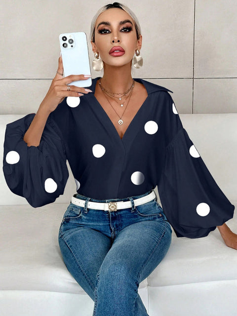 Polka dot, loose-fitting, puff-sleeved top with a semi-open collar.
