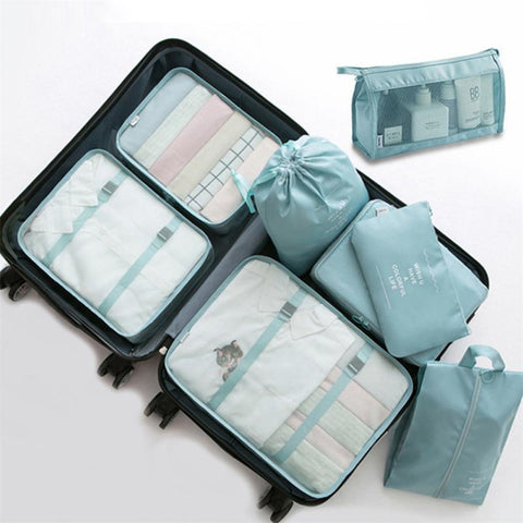 CJ 8-piece packing cube set in teal organized inside open suitcase for travel packing